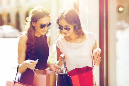 happy women with shopping bags in city